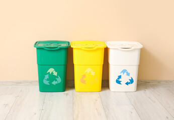 Containers for garbage near beige wall. Recycling concept