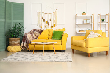 Interior of modern living room with stylish carpet, yellow sofa and armchair