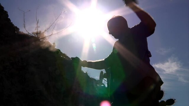 A man chisels rocks in the desert.