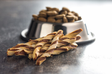 Dog food. Snack sticks for dogs on dark table.