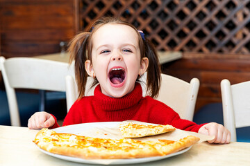 Funny little girl eating italian pizza for lunch close up. Charming happy child girl laugh and...