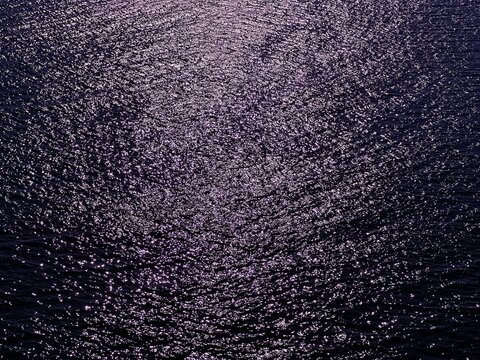 Glittering dark blue sea water surface at night 