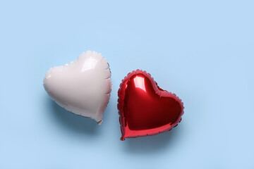 Heart shaped air balloons on blue background. Valentine's Day celebration © Pixel-Shot