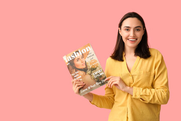 Beautiful woman with fashion magazine on pink background