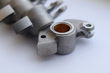 Light-weight alloy rocker arm with resist abrasion surface for contact with camshaft.