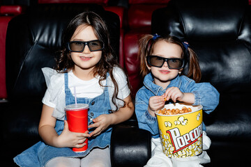 Little girls, friends or sisters in 3d glasses watching a cartoon film at a movie theater, house or...