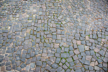 Stone wall with old bricks in the city. Gray stone block surface.