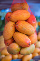 Display of Mangga Podang (Podang Mango variety) or Mangga Kenyot on a market stall. Originated from Kediri, East Java, Indonesia. Known for its vibrant red-orange skin, with sweet and juicy flesh.