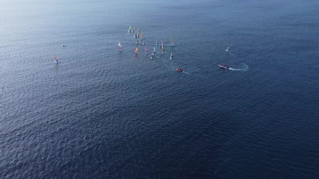 Windsurfers at the winter, aerial training footage 4k. This video made with a drone at sunset with a windsurfers on the board surfing at winter period in Loutsa, Greece