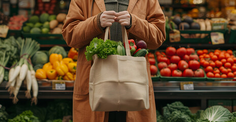 person's hand holding a reusable shopping bag with vegetables in the market