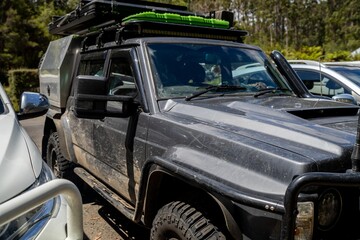 Fototapeta premium Camper trailer connected to a white car. SUV pulling a camper trailer with safety chains and wiring corrector