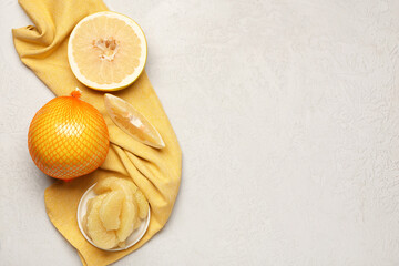 Plate with pieces of fresh pomelo fruit on white background