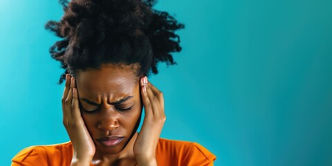 Close-up of a distressed african-american woman with a headache showing pain and discomfort on blue background 