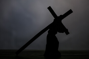 Jesus carrying wooden cross on grey background. Good Friday concept