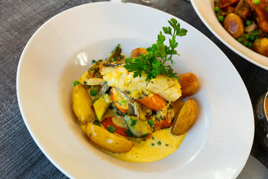 Hake fillet with vegetables and potatoes. French dish