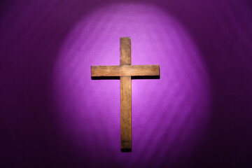 Wooden cross on purple background. Good Friday concept