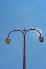Lamp post isolated on blue sky, taken on broad daylight.