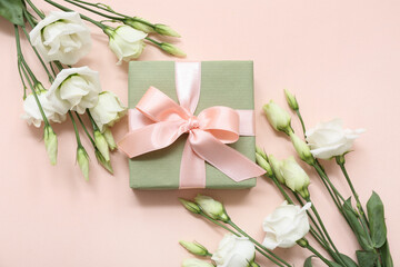 Gift box and beautiful white eustoma flowers on pink background. International Women's Day