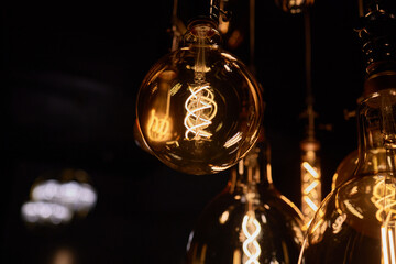Decorative incandescent bulbs in Edison style on a brick wall background.