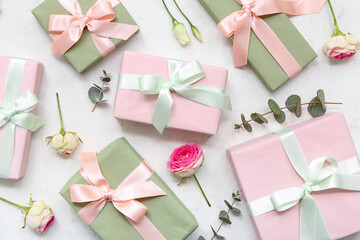 Gift boxes with beautiful roses and eucalyptus on white background. International Women's Day