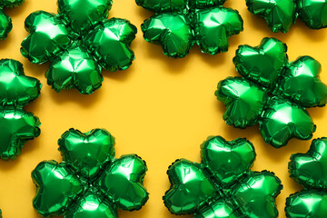 Frame made from balloons in shape of clover on yellow background. St. Patrick's Day celebration