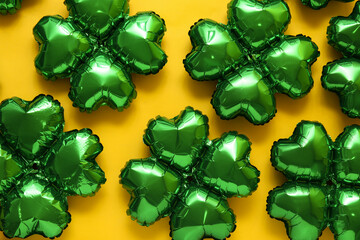 Balloons in shape of clover on yellow background. St. Patrick's Day celebration