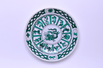 vintage plate with a dragon and other signs of the Chinese horoscope on a white background