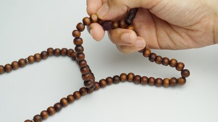 Muslim hand with prayer bead, isolated white background. Activity in Ramadhan