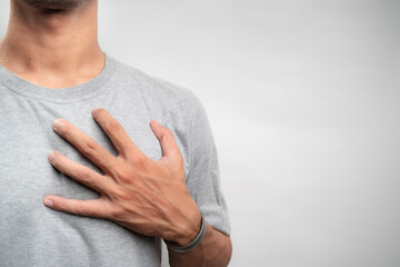 Young man having heart ache, holding hand on chest. Heart attack or stroke. risk of coronary heart...