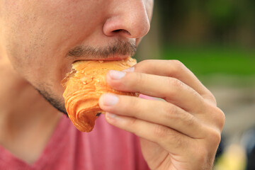 Chewing mouth while eating, guy eats sesame bread. Background with selective focus and copy space