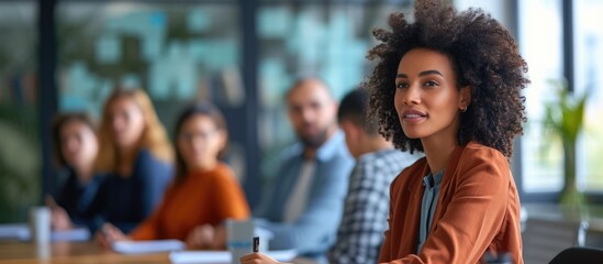 Obraz premium A captivating young speaker engages various employees of different ages during a business meeting, assisting in clarifying objectives and corporate goals. Colleagues then gather in the boardroom