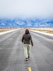 Obraz premium Young girl is walking on the road at Antelope Island State Park at Great Salt Lake in Utah