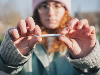 Woman Breaking Cigarette in Half, Quitting Smoking Concept