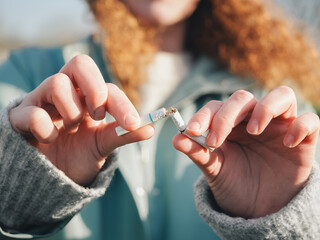 Young Woman Successfully Breaking a Cigarette, Quit Smoking Achievement