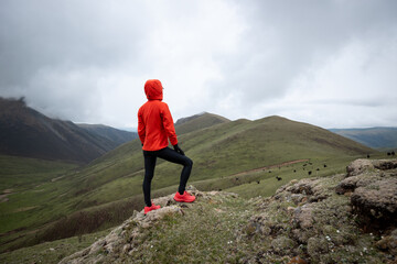 Obraz premium Woman trail runner looking at the view on high altitude mountain peak