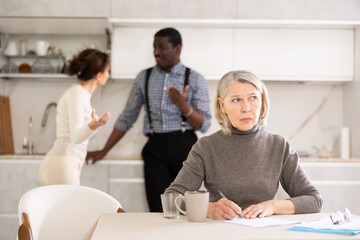 Couple man and woman discussing testament with elderly woman in kitchen at home