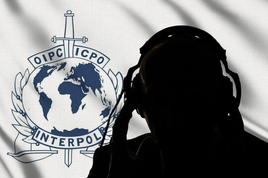 Dark silhouette of an interpol secret agent on the background of the flag of the secret service, eavesdropping on conversations, spy and special agent, Inscription in English, image of globe and sword