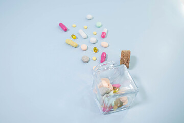 White color pills scattered on the table, close-up. Many pills in capsule form on the table.