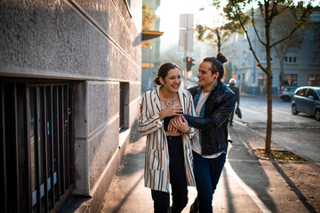 Young couple laughing and walking in the city
