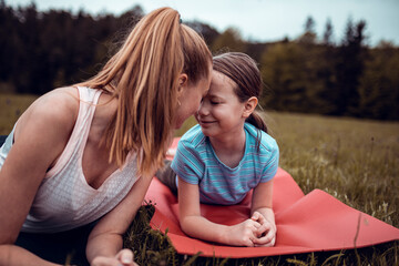Mother and daughter doing yoga in a forest