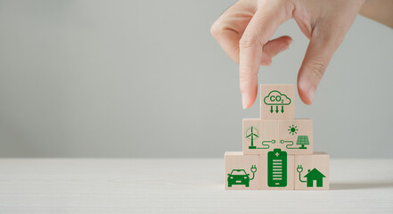Business people stack wooden cubes with CO2 carbon offsetting solution icons. Carbon credit tax,...