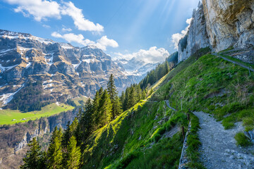 Swiss mountain trail at the Äscherhütte through steep, green meadows and forests with a...