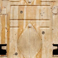 Seamless texture photo of rusty and worn armored desert camo vehicle surface with hatch.