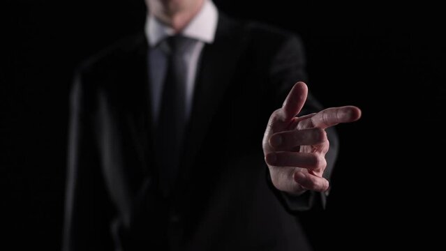 Business man leafing through an imaginary page with his finger on a black background