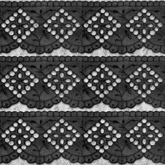 Seamless texture photo of black colored floral lace pattern on white background.