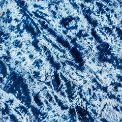 Seamless texture photo of blue colored wrinkled velvet drapery material.