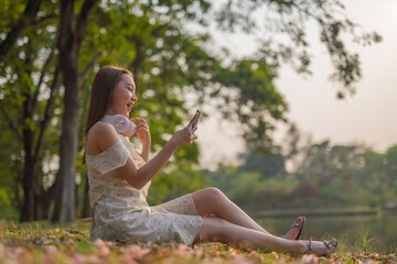 Young beautiful woman with headphone enjoying music and personal moment in a nature park