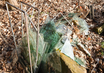 broken glass, window panes smashed in the woods, litter in the environment, non-removable pollution