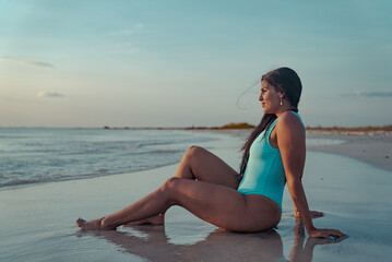 Vista de mujer latina al horizonte en el mar a la orilla de la playa