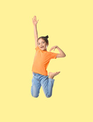 Happy cute girl jumping on beige background